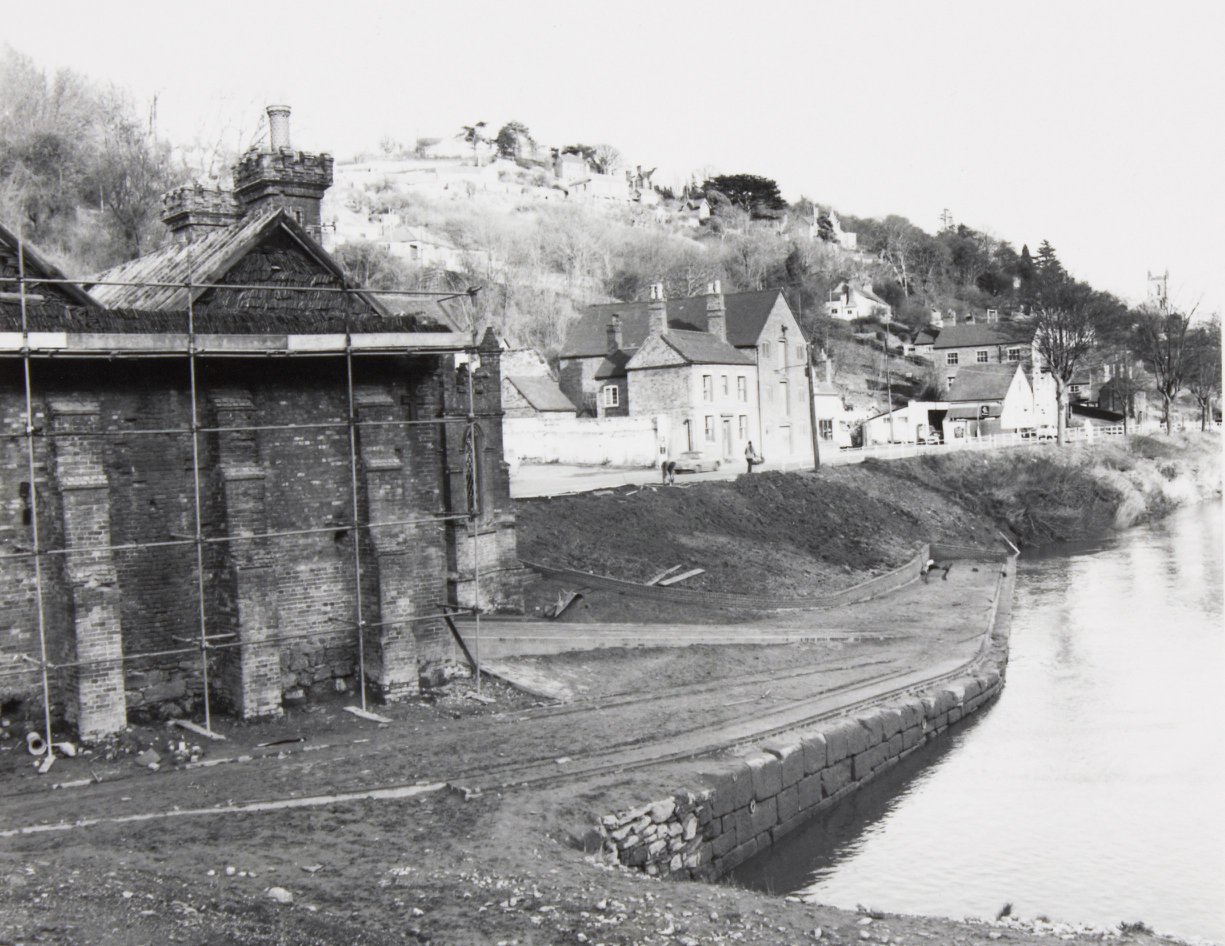 Scaffolded from the riverbank, with the Wharfage houses beyond
