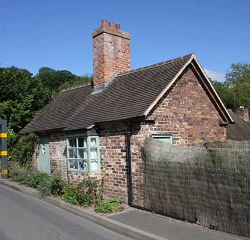 The restored brick toll cottage as it stands today, Grade II listed since 2002 after its 1990s rescue from dereliction. It's now a private home, so please enjoy the view and take your photographs from the road — the building's second life depends on the ongoing goodwill of the people who live there.