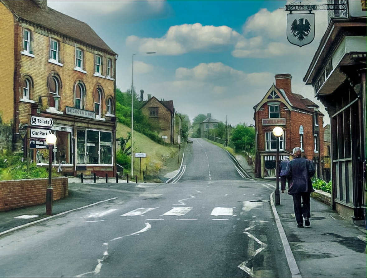 Later street photograph looking along the road, with Beddoes & Son on the left and Woolleys on the right.