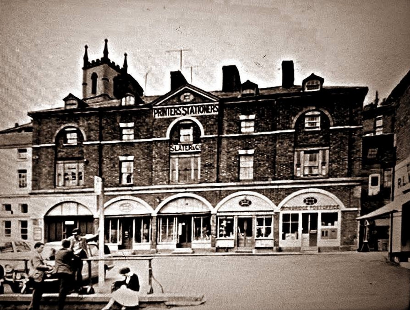 The arcade lettered "Printers Stationers" and "Slater & Co", with the Post Office working out of one of the arches. Each arch held a different trade, which is why the frontage carries so many names at once — a small indoor high street. Exact date unknown.