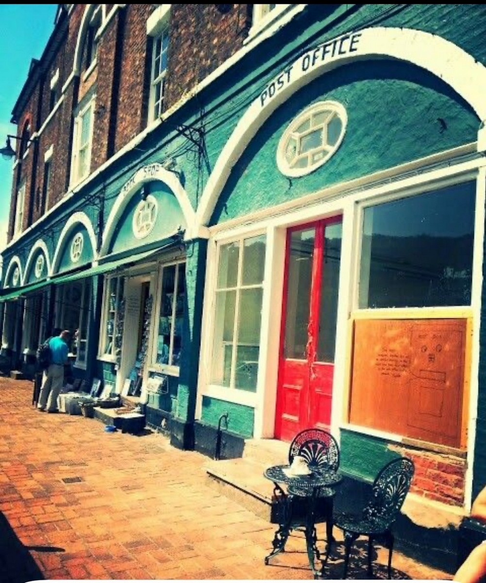 The run of arches in deep green and cream, the Post Office at the near end. Painting the whole range in one colour scheme made a Victorian market building look like a modern parade of shops — a common bit of mid-century tidying up. Exact date unknown.