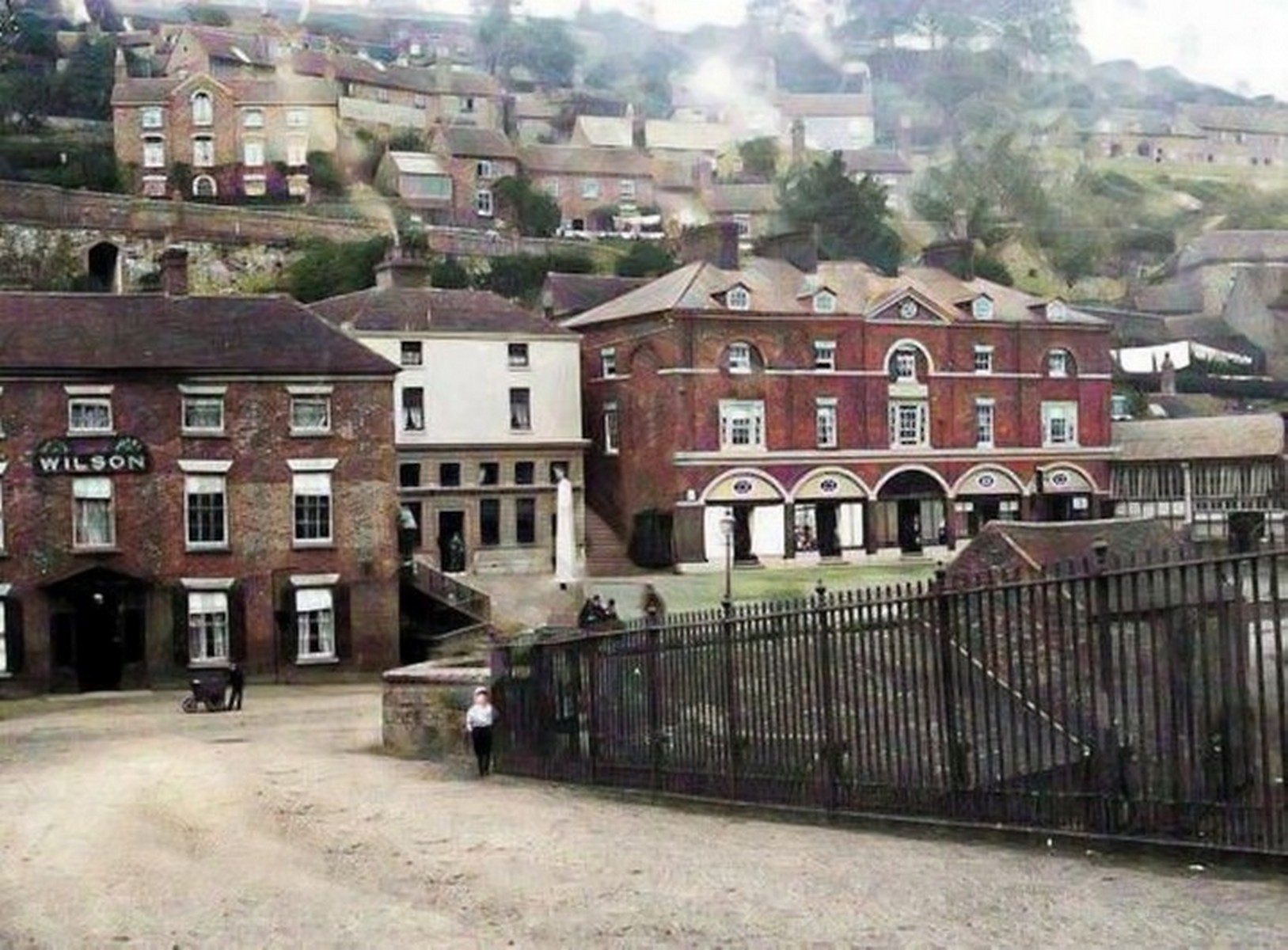 The obelisk still in its place, with the first motor cars drawn up along the wall beside it. Two ages sharing one photograph — the Victorian drinking fountain and the vehicles that would eventually push it to the edge of the Square. Exact date unknown.