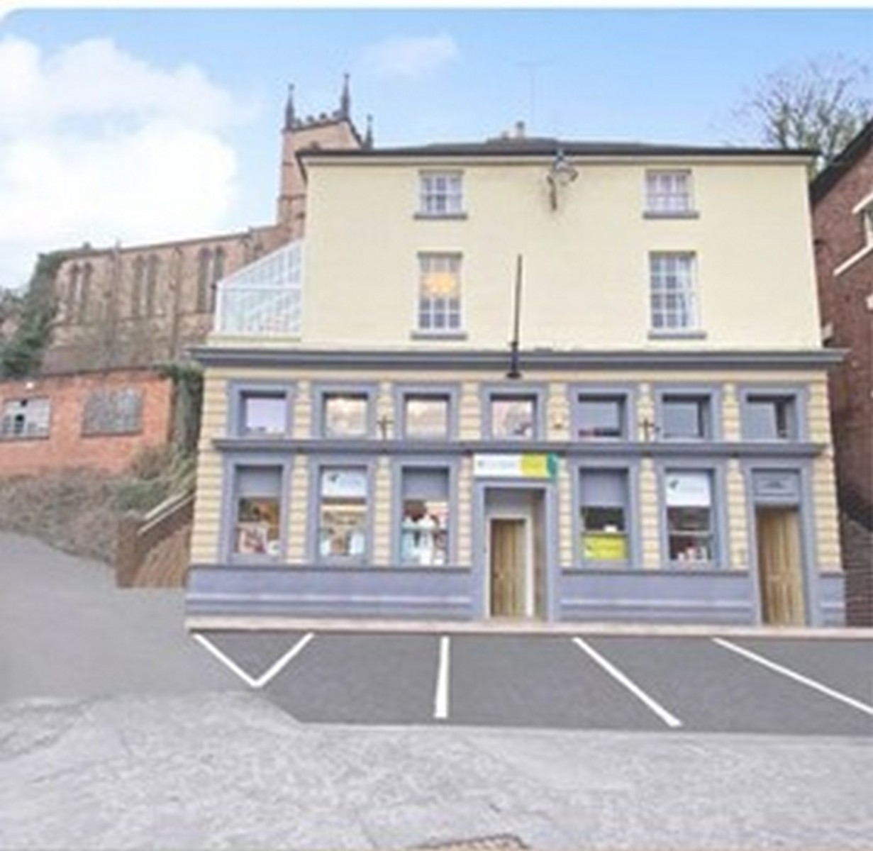 The former bank building today in cream and grey, standing above the parking bays. The proportions are unchanged — tall ground-floor windows built to look solid and reassuring, as bank frontages always were. Present day.